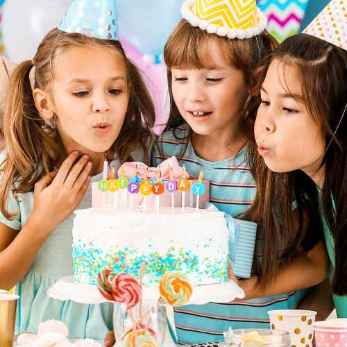 kids blowing candles on cake